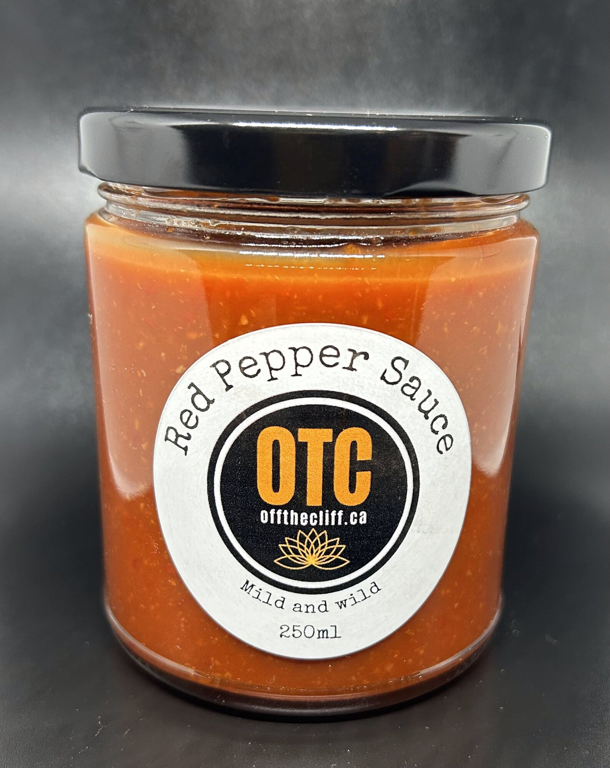 OTC Red Pepper Sauce, Mild and Wild, 250 ml jar on a dark background